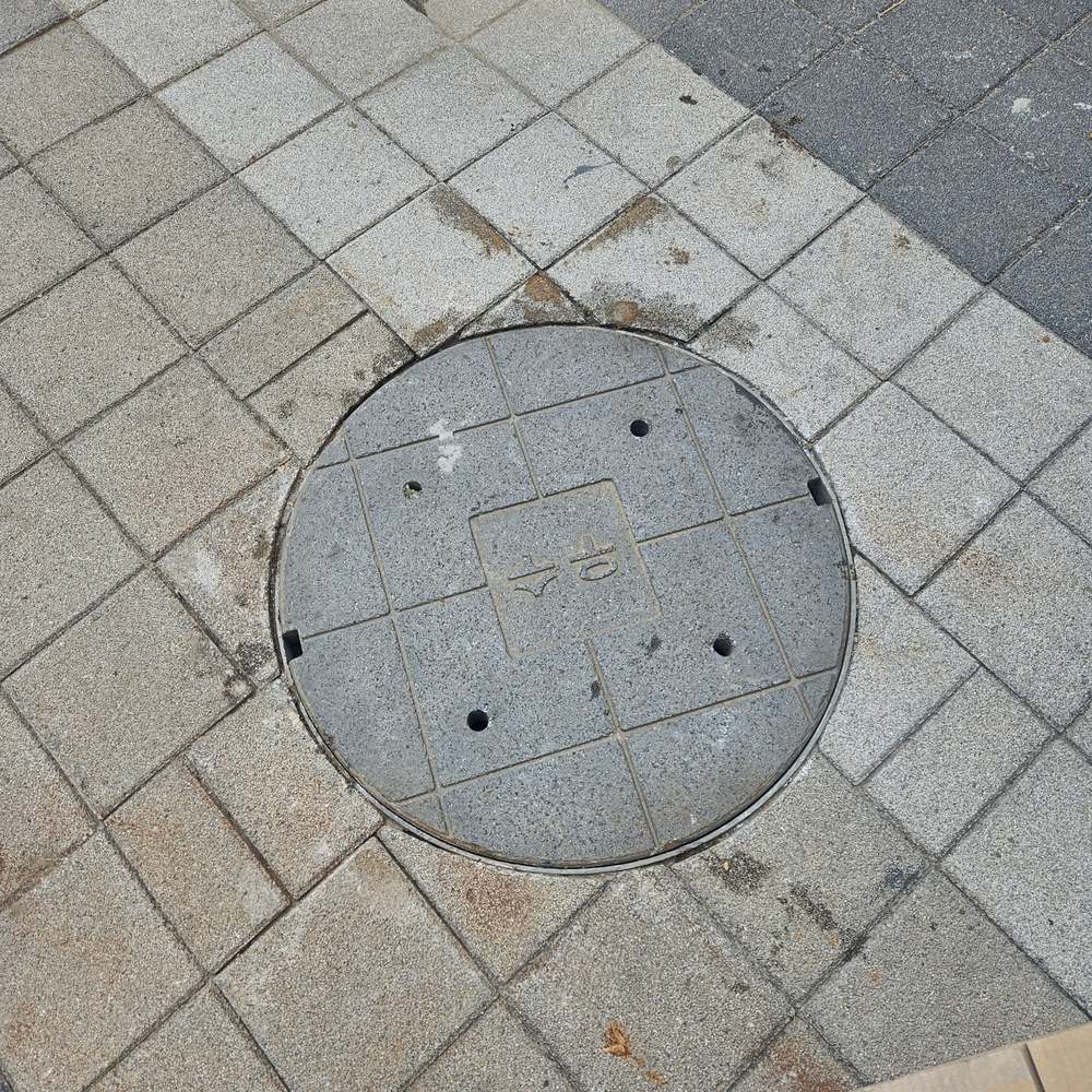 상가 보도블록에 닫혀 있는 오수맨홀 뚜껑