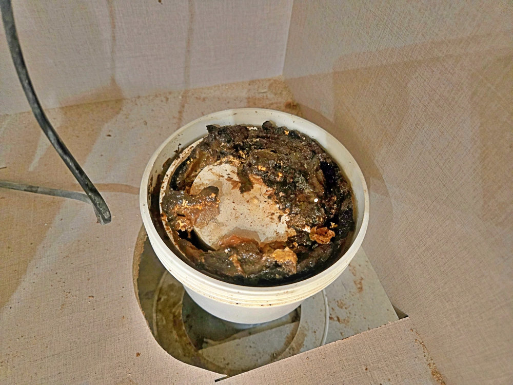 기름때와 검은 찌꺼기가 가득 쌓인 배수 연결캡